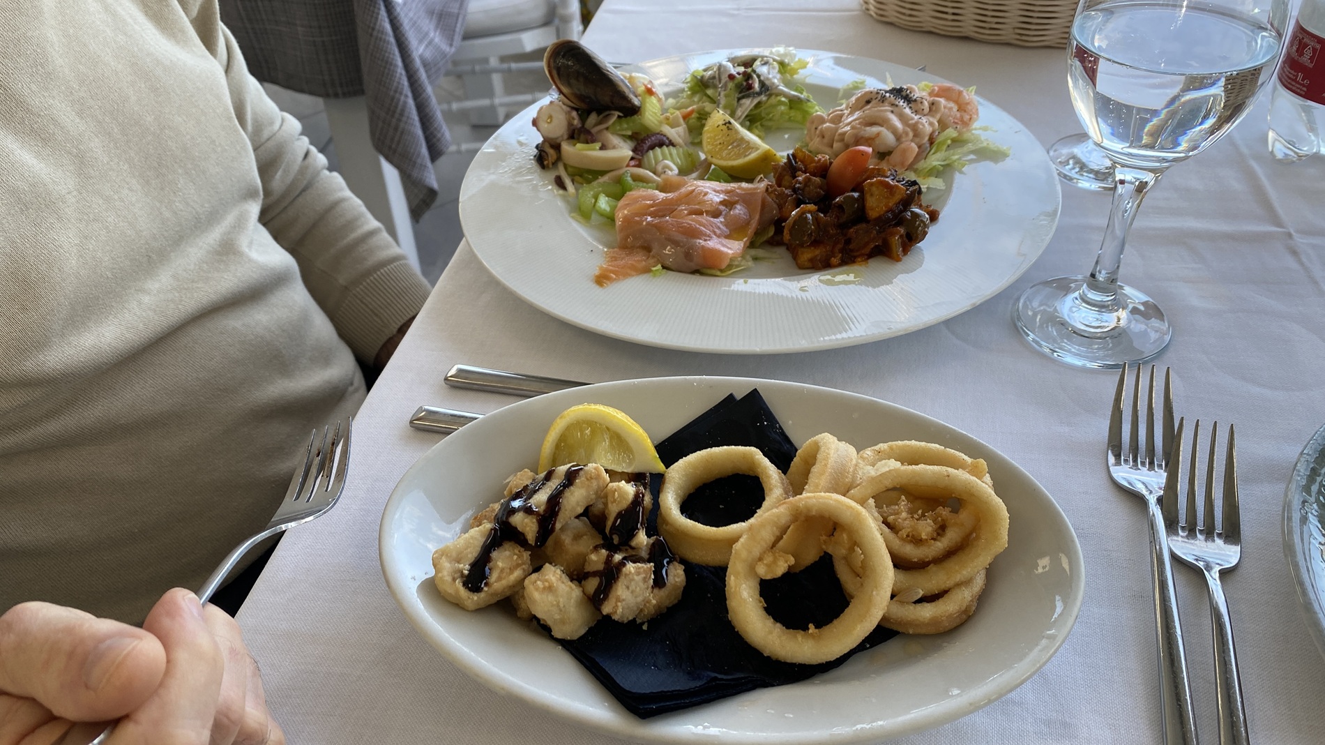 Fried cod, calamari rings, and shrimp salad served at a seaside restaurant in Sferracavallo, Sicily during spring in Sicily